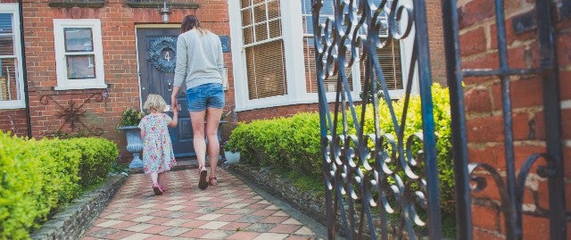 Woman and child walking towards a front door