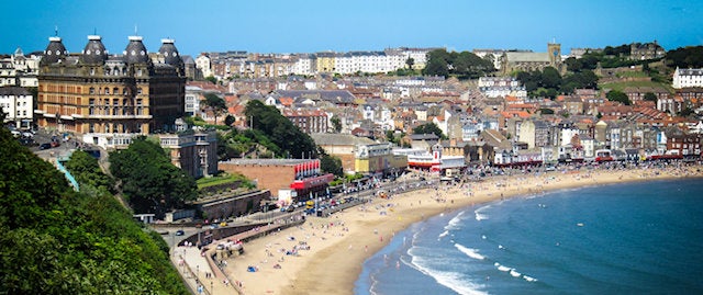 Busy long stretch of sand in Scarborough on a summers day