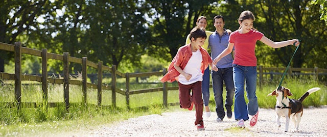 family having fun on a walk with a dog