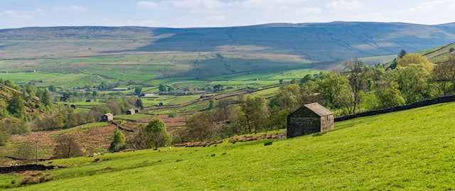 a small stone building on an uneven landscape