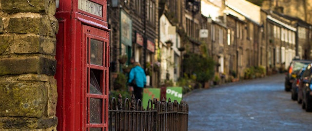 A classic red phone box at the bottom of a cobbled inclining path