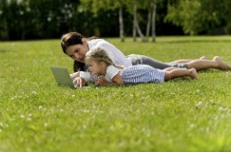 Mother and daughter laid on some grass
