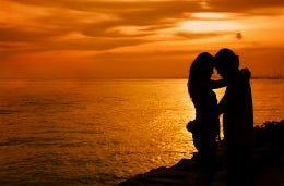A couple embracing silhouetted against the sunset