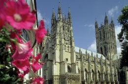 Five Things You Didn’t Know About Canterbury (and Some You Did) A picture of the magnificent Canterbury Cathedral bordered by pink flowers.
