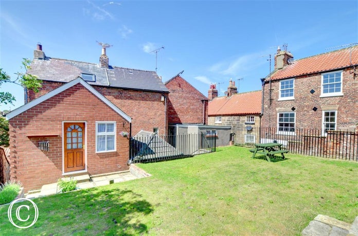 Large spacious garden with picnic style table.